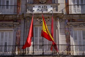 Detailed view of Plaza Mayor's facade with flags in Madrid, Spain, highlighting classic architecture.