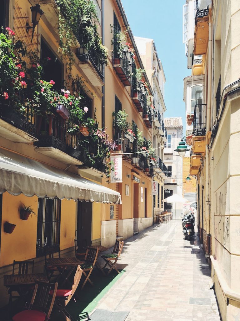 empty seats and tables in between buildings during daytime